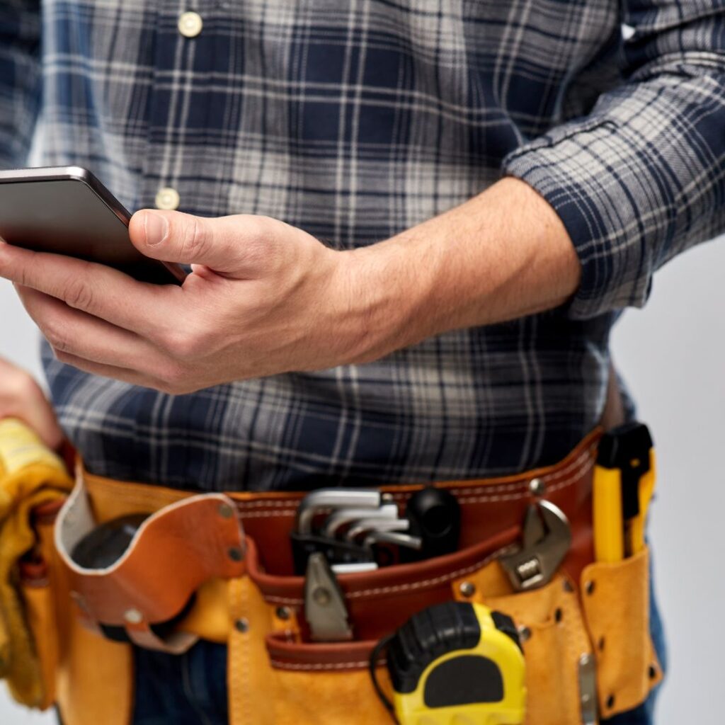 A roofing contractor using his cell phone to contact an insurance provider