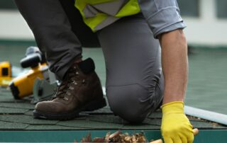 Contractor on a roof inspecting and installing gutters