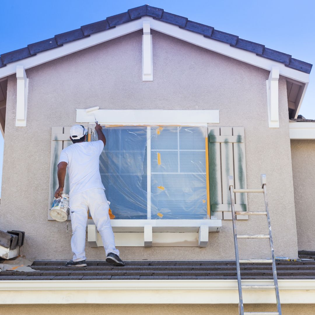 man painting exterior of a house